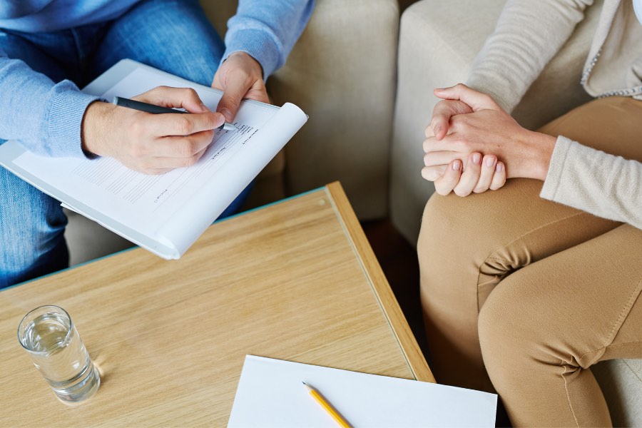 patient and counsellor taking notes in psychotherapy session