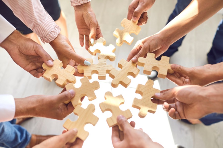 Team of professionals joining a puzzle together