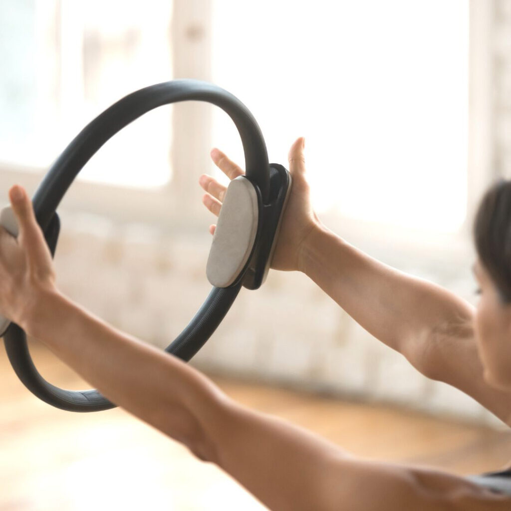 Woman doing clinical pilates exercise with pilates ring